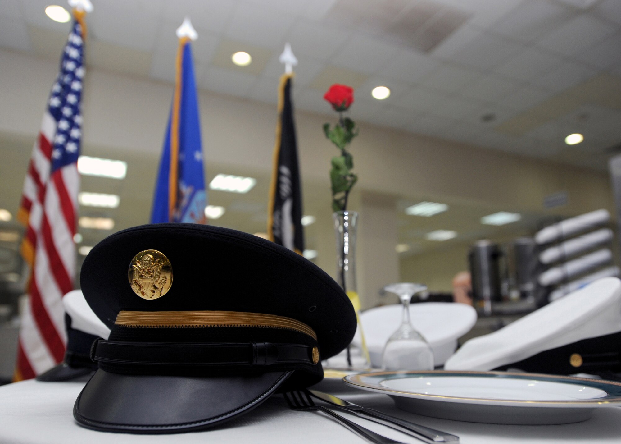 SOUTHWEST ASIA -- A display in the 386th Air Expeditionary Wing dining facility honors U.S. prisoners of war and troops reported as missing in action as part of National POW/MIA Recognition Day, held Sept. 17, 2010. The vacant table, featuring headgear from all the military services, is a symbolic tribute to the American men and women who never returned from combat, to those who suffered as prisoners of war in distant lands, and to all servicemembers who have defended America with unwavering devotion. (U.S. Air Force photo by Senior Airman Laura Turner)