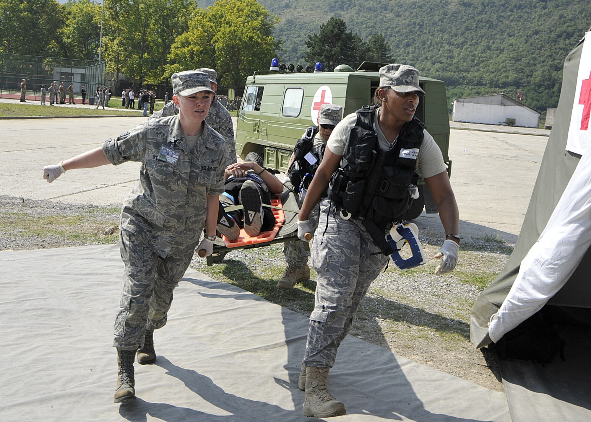 United States Air Force Tech. Sgt. Tonya O'Toole, Staff Sgt. Kamesha Lewis, Staff Sgt. Jacob Good and Staff Sgt. Vince Remo, (left to right), all of the 48th Medical Group at RAF Lakenheath, England, carry an acting victim on a litter during a medical exercise scenario as government ministers, flag officers and other distinguished visitors watch during MEDCEUR 10, a medical training exercise in central and eastern Europe, at Danilovgrad Army Base, Montenegro Sept. 17. For more information, go to www.usafe.af.mil/medceur.asp and www.odbrana.gov.me. (U.S. Air Force photo/Airman 1st Class Tiffany M. Deuel)
