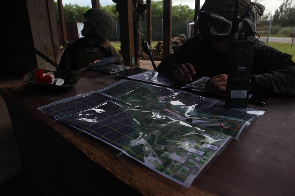 1st Lt. Jason Pohly, a Platoon Commander with Charlie Company, Battalion Landing Team 1st Battalion, 7th Marines, 31st Marine Expeditionary Unit, and Capt. Trent Metlin, a forward air controller with Charlie Company, plot points on a map during a helicopter raid on the coast of Guam in support of the certification exercise conducted by the 31st MEU.