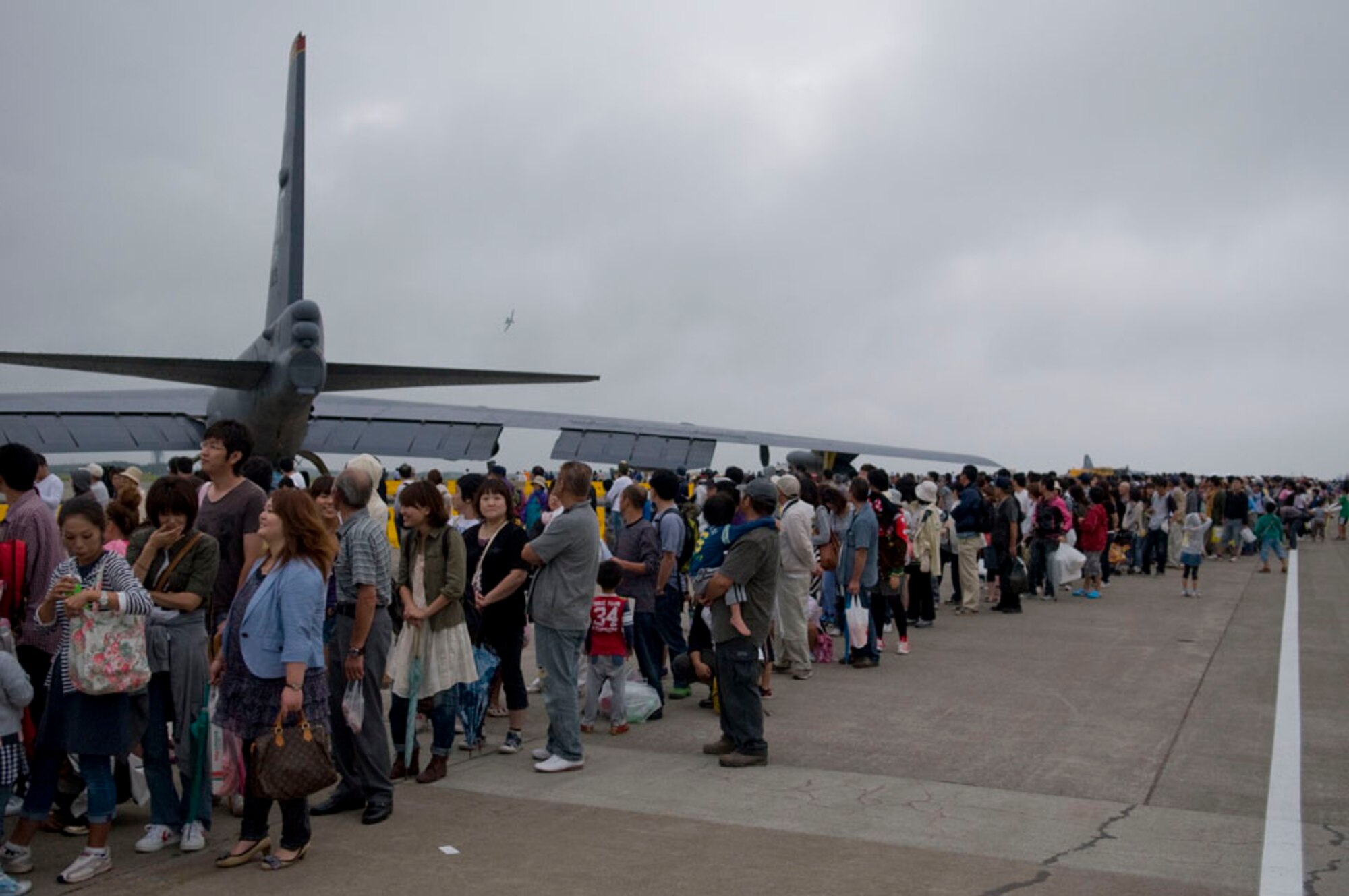 A line of visitors look at an aerial demonstration during the air festival, Sept. 19, 2010, at Misawa Air Base, Japan. Japan Air Self-Defense Force led the event, which featured their premier aerial demonstration team, Blue Impulse. U.S. Air Force aviators also performed demonstrations during the event. (U.S Air Force photo by Senior Airman Jessica Lockoski/Released)