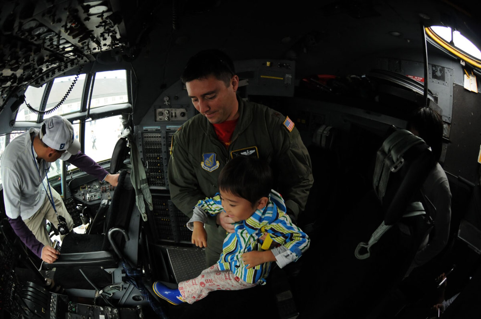 U.S. Air Force Maj. Michael Fugett, a C-130 Hercules aircraft commander from the 36th Airlift Squadron, Yokota Air Base, Japan, puts Subaru Magata into the navigator’s seat of an aircraft at an air festival, Sept. 19, 2010, at Misawa Air Base, Japan.  More than 110,000 guests attended the event, commemorating the 50th anniversary of the Treaty of Mutual Cooperation and Security between Japan and the United States. (U.S Air Force photo by Senior Airman Jessica Lockoski/Released)