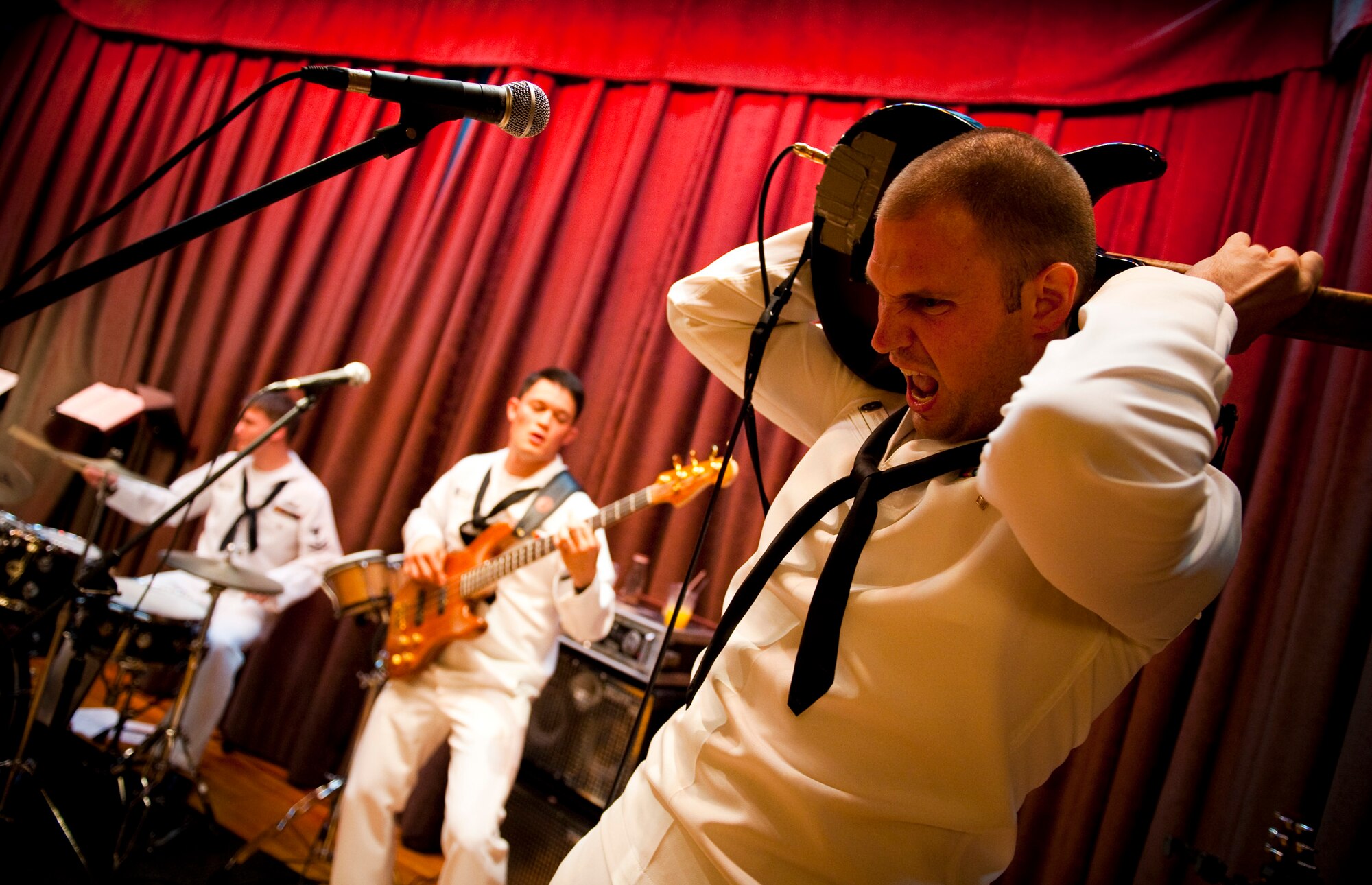 U.S. Navy Petty Officer 3rd Class Christopher Kopp, 7th Fleet Band "Orient Express" guitarist, plays a guitar solo behind his head during the Misawa Air Festival 2010 air crew reception at the collocated club, Misawa Air Base, Japan, Sept. 18 2010. The band visited Misawa from Yokosuka, Japan. (U.S. Air Force photo by Staff Sgt. Samuel Morse/Released)