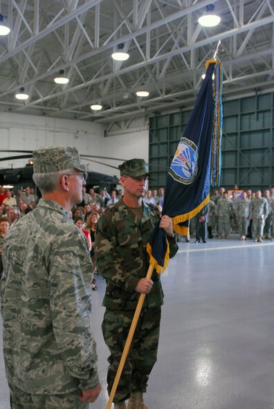 Navy Rear Adm. Thomas L. Brown II holds the U.S. Special Operations Command South unit colors after Air Force Gen. Douglas Fraser (left), combatant commander of U.S. Southern Command, hands it to him. The passing of the colors officially made Brown the new commander of SOCSOUTH during the change of command ceremony on Sept. 17 at Homestead Air Reserve Base, Fla. (Department of Defense photo/Dwayne Lester, SOCSOUTH Public Affairs)