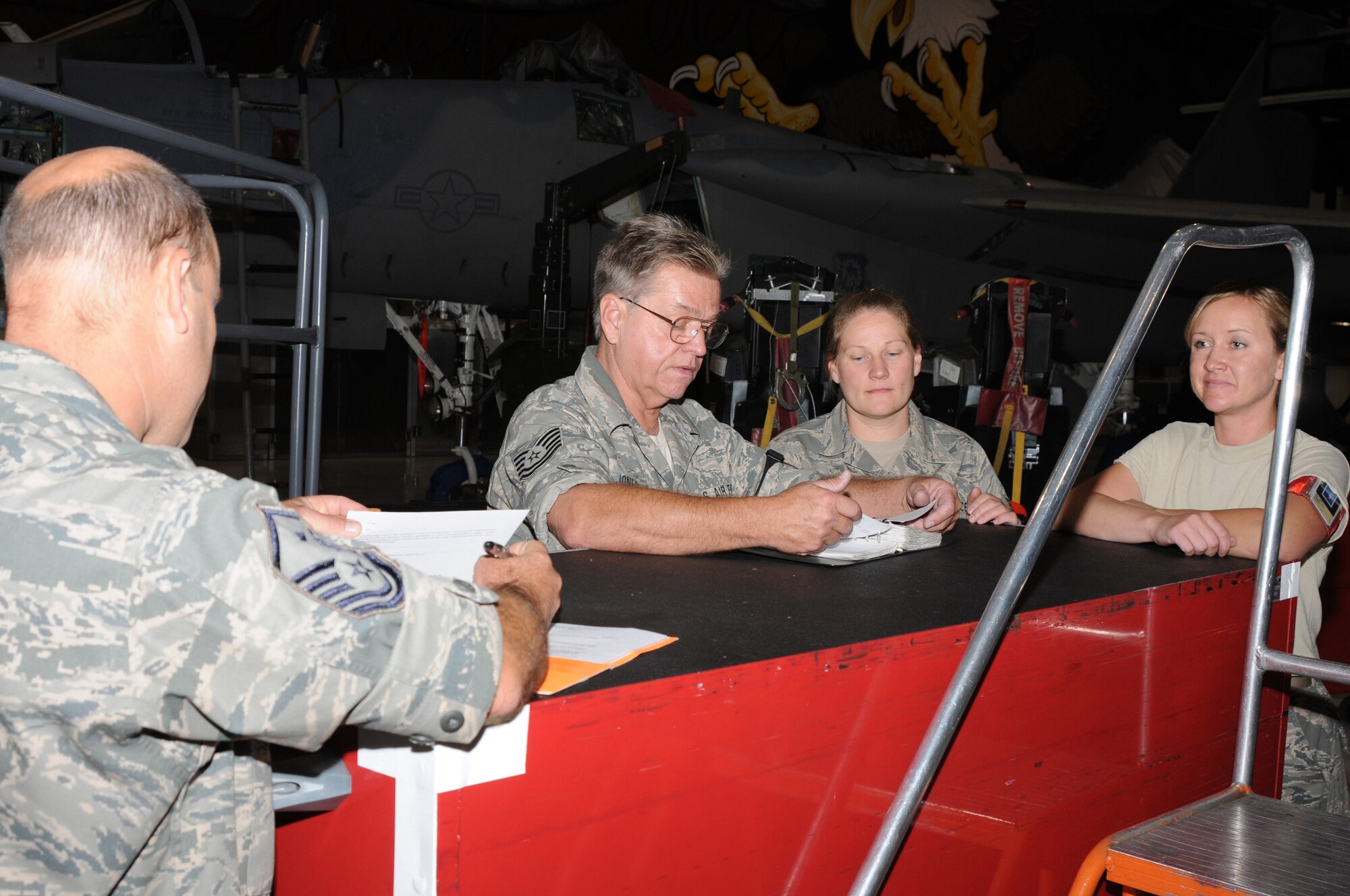 Tech. Sergeant Jeffrey Jones, Barbara Cloninger and Staff Sergeant Jennifer Hall, all airmen in the 173rd Fighter Wing egress shop, review a manual with a member of the Unit Compliance Inspection team at Kingsley Field, Ore., September 18, 2010.  Kingsley Field has been under the microscope by the UCI team this week to ensure the base is performing up to Air Force standards.  (U.S. Air Force photo by Senior Airman Bryan Nealy.) Released