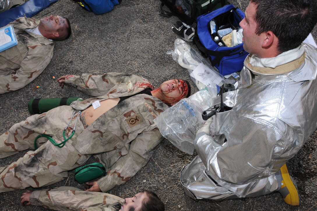173rd Fighter Wing firefighter Vince Lomabardo works to find the extent of a victims injuries after dragging 2nd Lt. Janzaldie Francisco to safety during an exercise featuring a simulated aircraft crash.  The exercise was part of a Unit Compliance Inspection held Sept. 17, 2010 at Kingsley Field in Klamath Falls, Ore. and featured the bases ability to respond to a disaster of this nature.