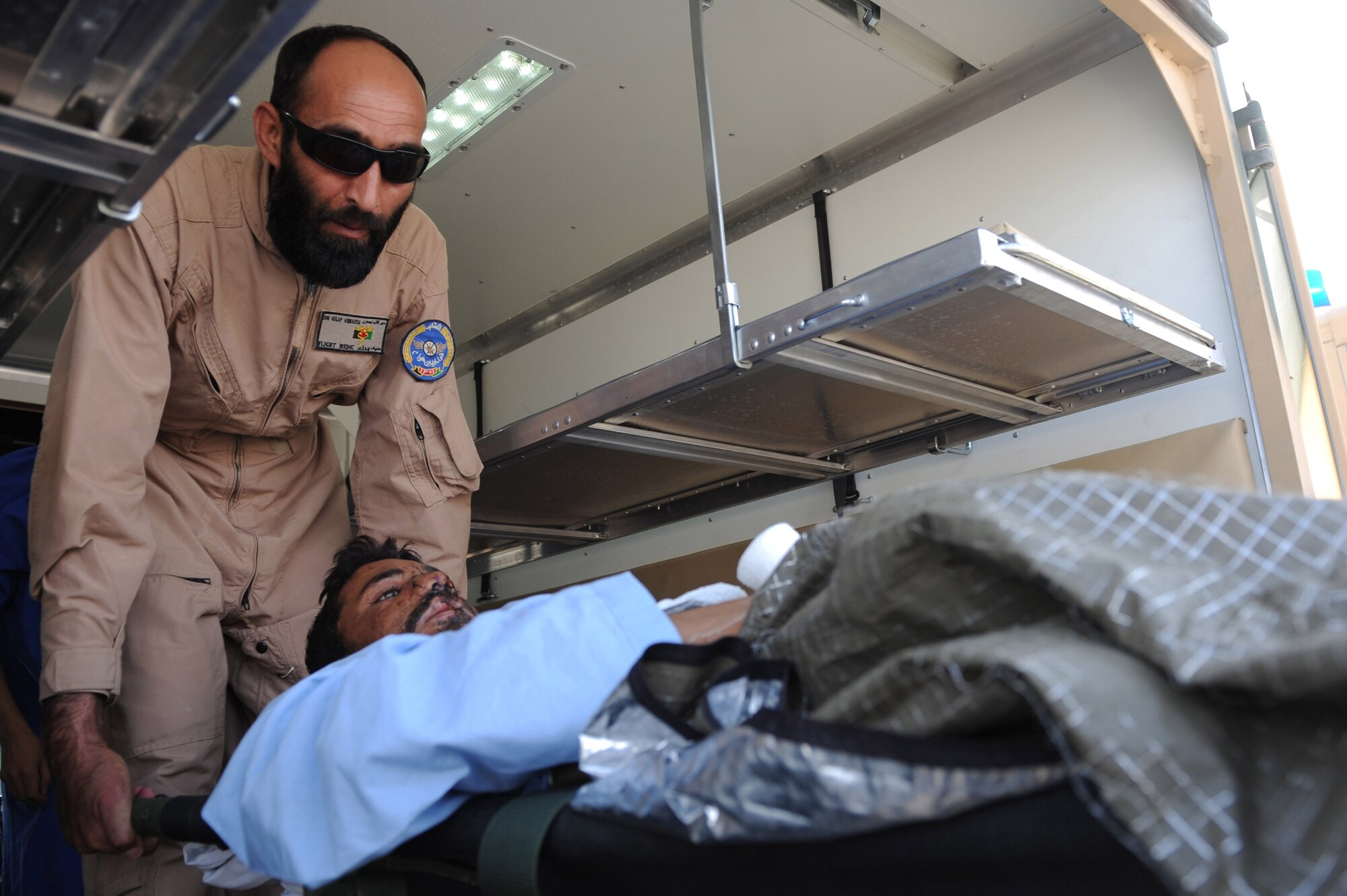 Sgt. Sur Gulap lowers an injured patient from the rear of an ambulance Sept. 12, 2010, at Kandahar Airfield, Afghanistan.  Afghan flight medics and 451st Expeditionary Aeromedical Evacuation Squadron Airmen successfully transferred 12 patients from Kandahar Airfield, to Kabul, Afghanistan, using aeromedical evacuation.  Sergeant Sur Gulap is a flight medic with the Afghan Air Force, Kandahar Air Wing Medical Group.  (U.S. Air Force photo by Tech. Sgt. Chad Chisholm/Released)   