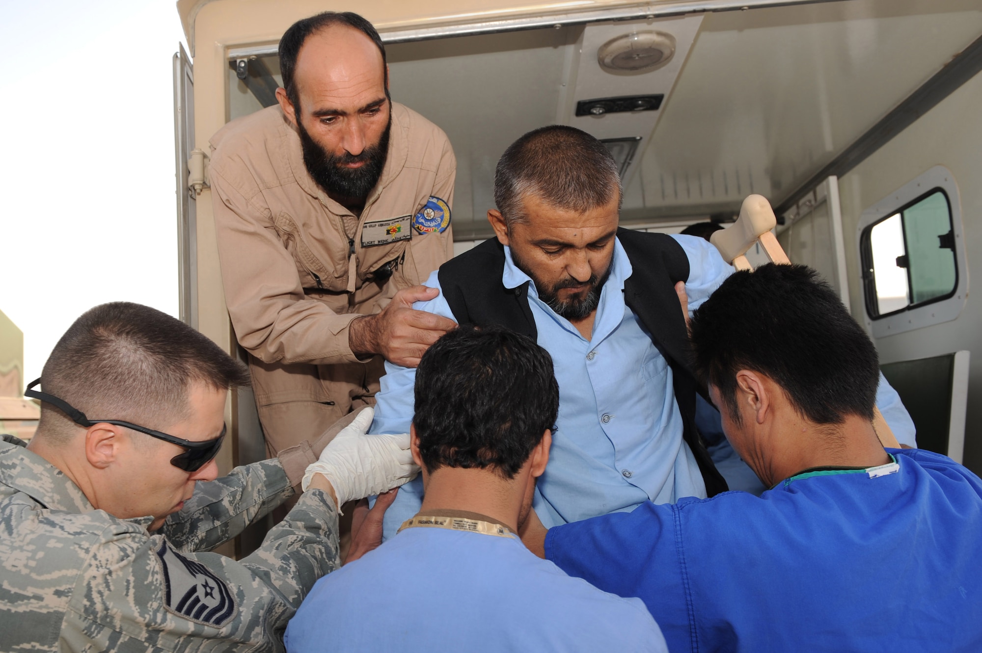 Afghan medical personnel and coalition partners lower an injured patient from an ambulance Sept. 12, 2010, at Kandahar Airfield, Afghanistan.  Afghan flight medics and 451st Expeditionary Aeromedical Evacuation Squadron Airmen successfully transferred 12 patients from Kandahar Airfield, Afghanistan, to Kabul using aeromedical evacuation.    (U.S. Air Force photo by Tech. Sgt. Chad Chisholm/Released)