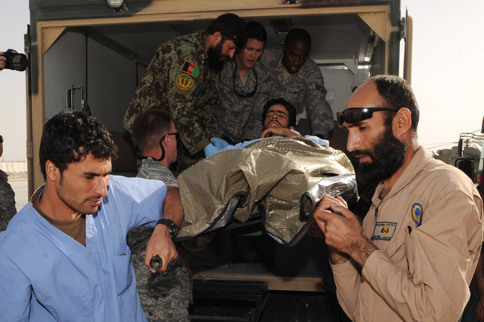 Afghan medical personnel and coalition partners lower an injured patient from an ambulance Sept. 12, 2010, at Kandahar Airfield, Afghanistan.  Afghan flight medics and 451st Expeditionary Aeromedical Evacuation Squadron Airmen successfully transferred 12 patients from Kandahar Airfield, Afghanistan, to Kabul using aeromedical evacuation.  (U.S. Air Force photo by Tech. Sgt. Chad Chisholm/Released)