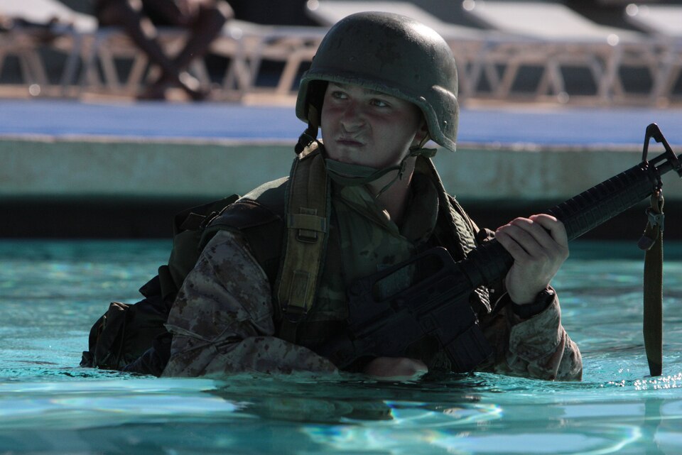 Corporal Colby Staples, a Corporals Course student, storms his way across the pool with his rubber M16 during the Combat Logistics Battalion 7-sponsored Corporals Course swim qualification at the Combat Center’s Training Tank Monday.