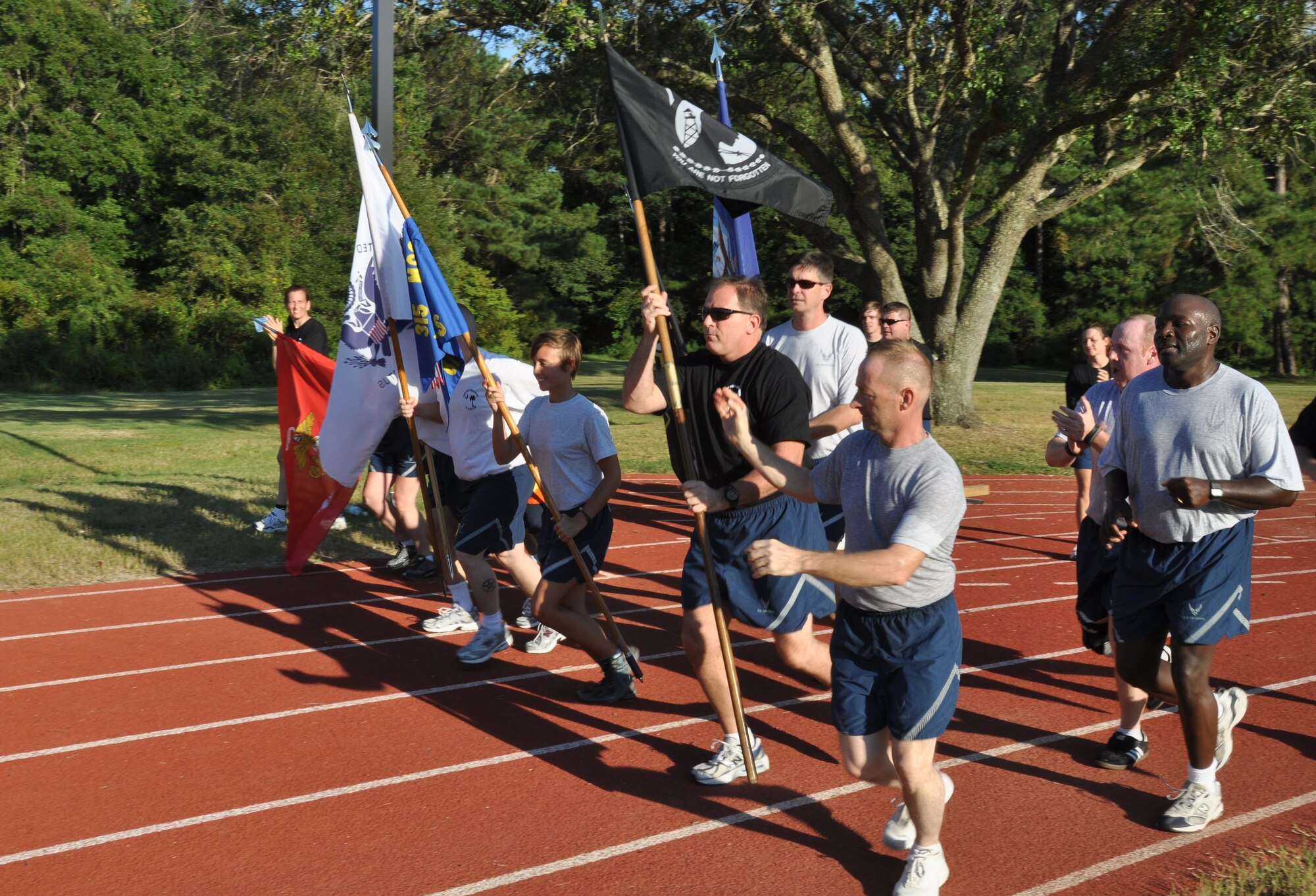 Members from the 315th Security Forces Squadron pass the POW/MIA flag to members of the 81st Aerial Port Squadron during the 4th annual Charleston Air Force Base POW/MIA 24-hour vigil run Sept. 16, 2010 at the base running track. (U.S. Air Force Photo/Staff Sgt. Shane Ellis)
