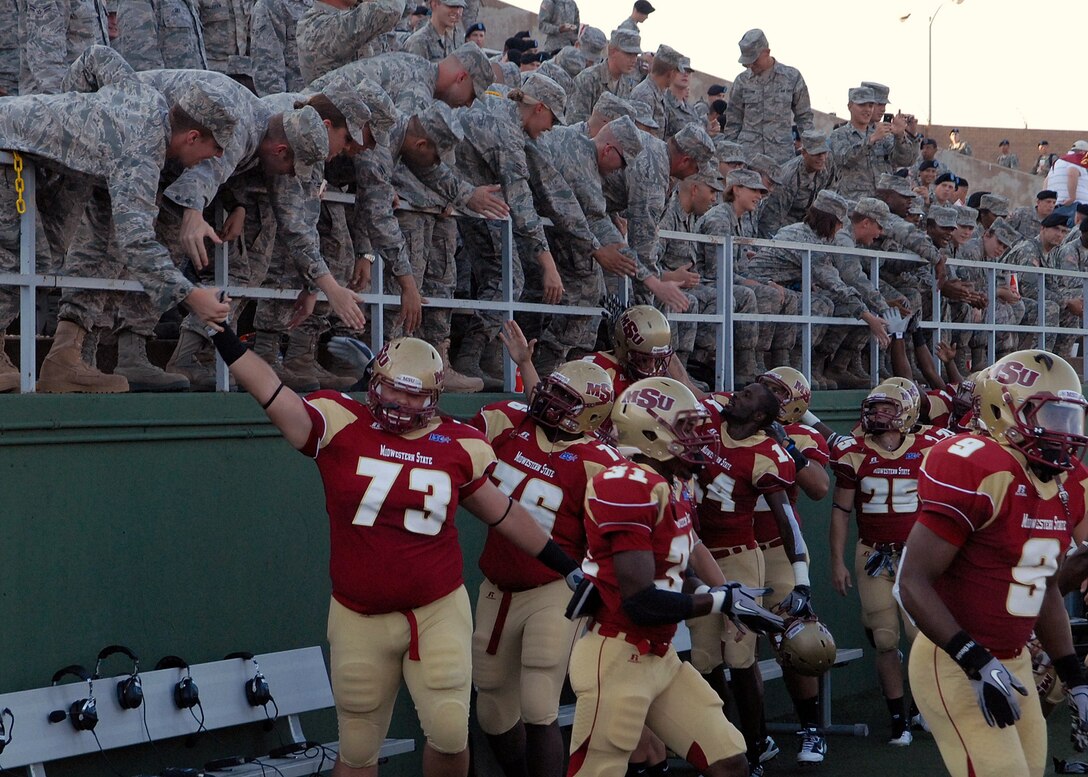Airmen in Training from Sheppard Air Force Base, Texas, greet the Midwestern State University football team as they prepare to take the field during the annual MSU Military Appreciation Game at Memorial Stadium in Wichita Falls, Texas Sept. 18.  More than 1,200 members from Sheppard and Fort Sill, Okla., were in attendance for the game.  (U.S. Air Force photo/LouAnne Sledge)