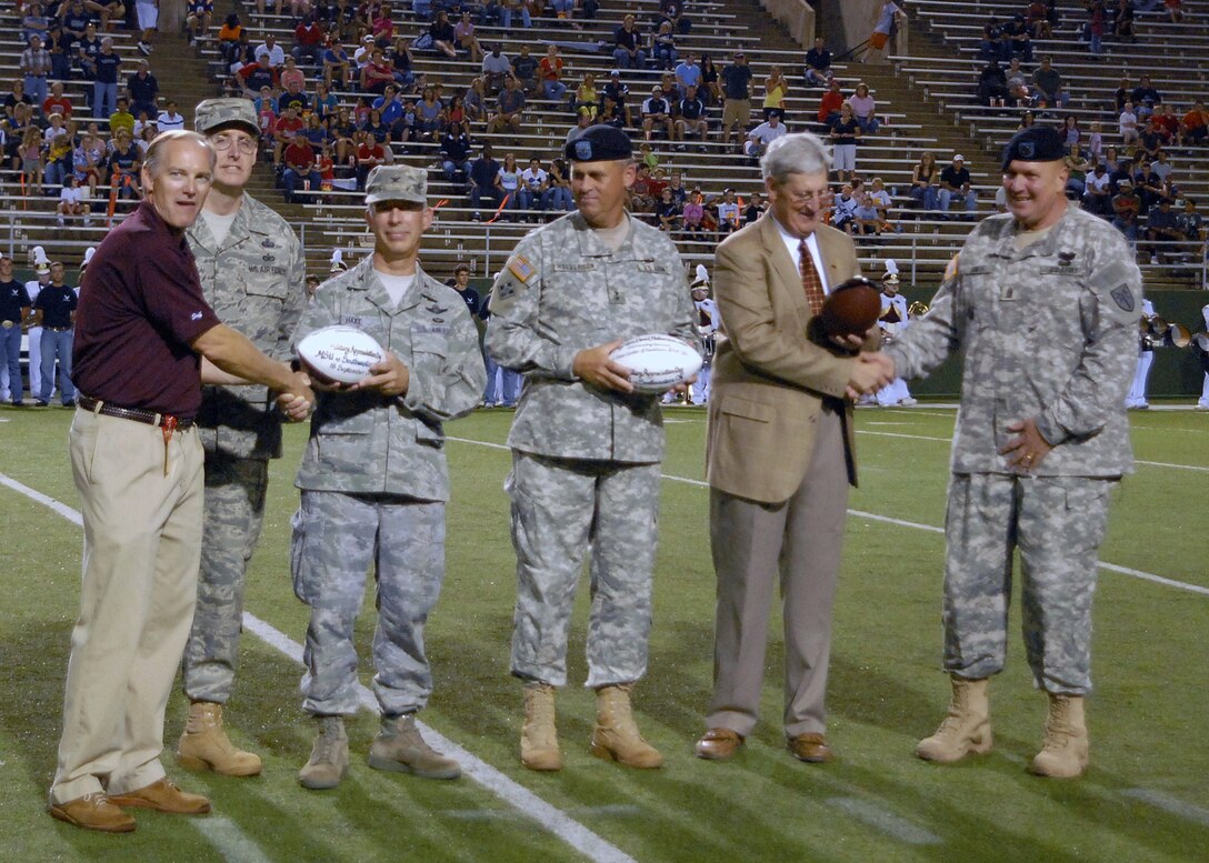 Representatives from Sheppard Air Force Base, Texas; Fort Sill Garrison, Okla.; and Midwestern State University in Wichita Falls, Texas, exchange greetings as they open the MSU Military Appreciation Game.  (Left to right) Kyle Williams, director of corporate and sports development; Chief David Nelson, 82nd Training Wing command chief; Col. Michael Hake, 82nd TRW vice commander; Maj. Gen. David Halverson, Fires Center of Excellence and Fort Sill commanding general; Dr. Jesse Rogers, MSU president; and  Fires Center of Excellence Command Sgt. Maj. Joseph Smith, were honored on the field.  (U.S. Air Force photo/LouAnne Sledge)
