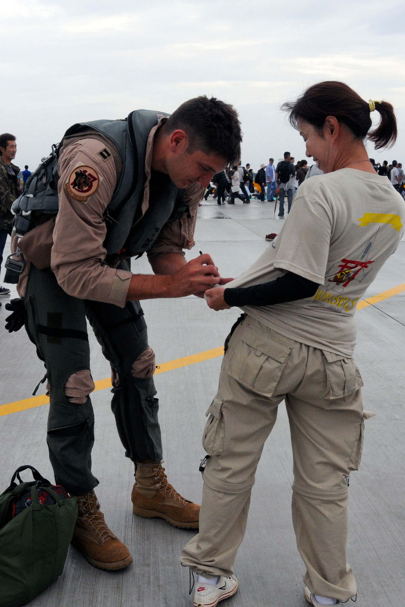 An F-16 Fighting Falcon pilot from the 13th Fighter Squadron autographs a fan’s T-shirt at the Misawa Air Festival Sept. 19, 2010, at Misawa Air Base, Japan. (U.S. Air Force photo/Tech. Sgt. Kelly White)