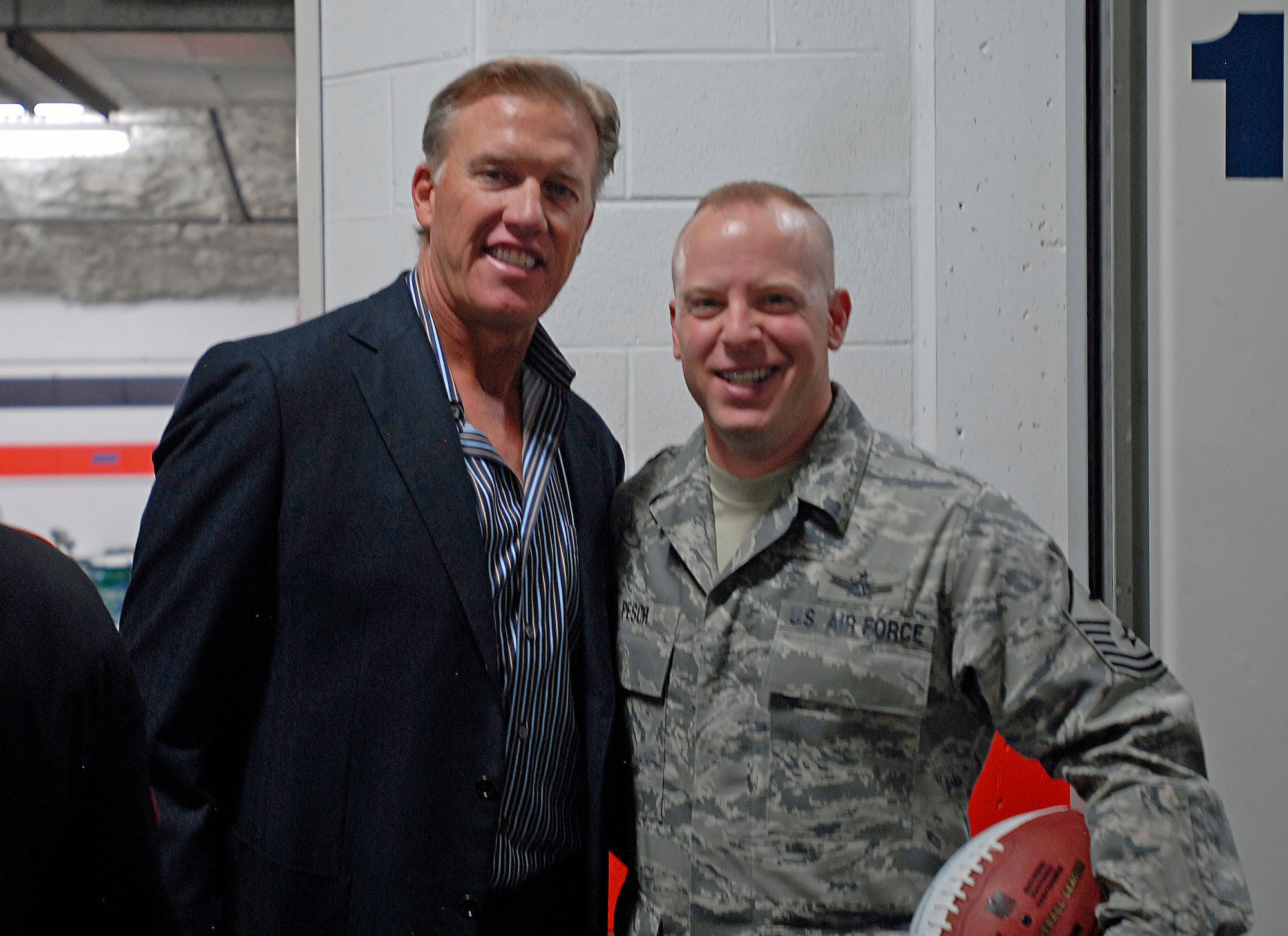 PETERSON AIR FORCE BASE, Colo. –Former quarterback for the Denver Broncos, John Elway, presented an honorary football to the Airmen of Peterson Air Force Base, Colo. Sept. 19 at Invesco Field in Denver.  The game ball was given to Master Sgt. David Pesch (right), first sergeant, 21st Space Wing director of staff.  Each year, the Denver Broncos salute military servicemembers by presenting all four branches of service with a football and hosting a pre-game ceremony to honor the U.S military. (U.S. Air Force photo/Airman 1st Class Jessica Hines)