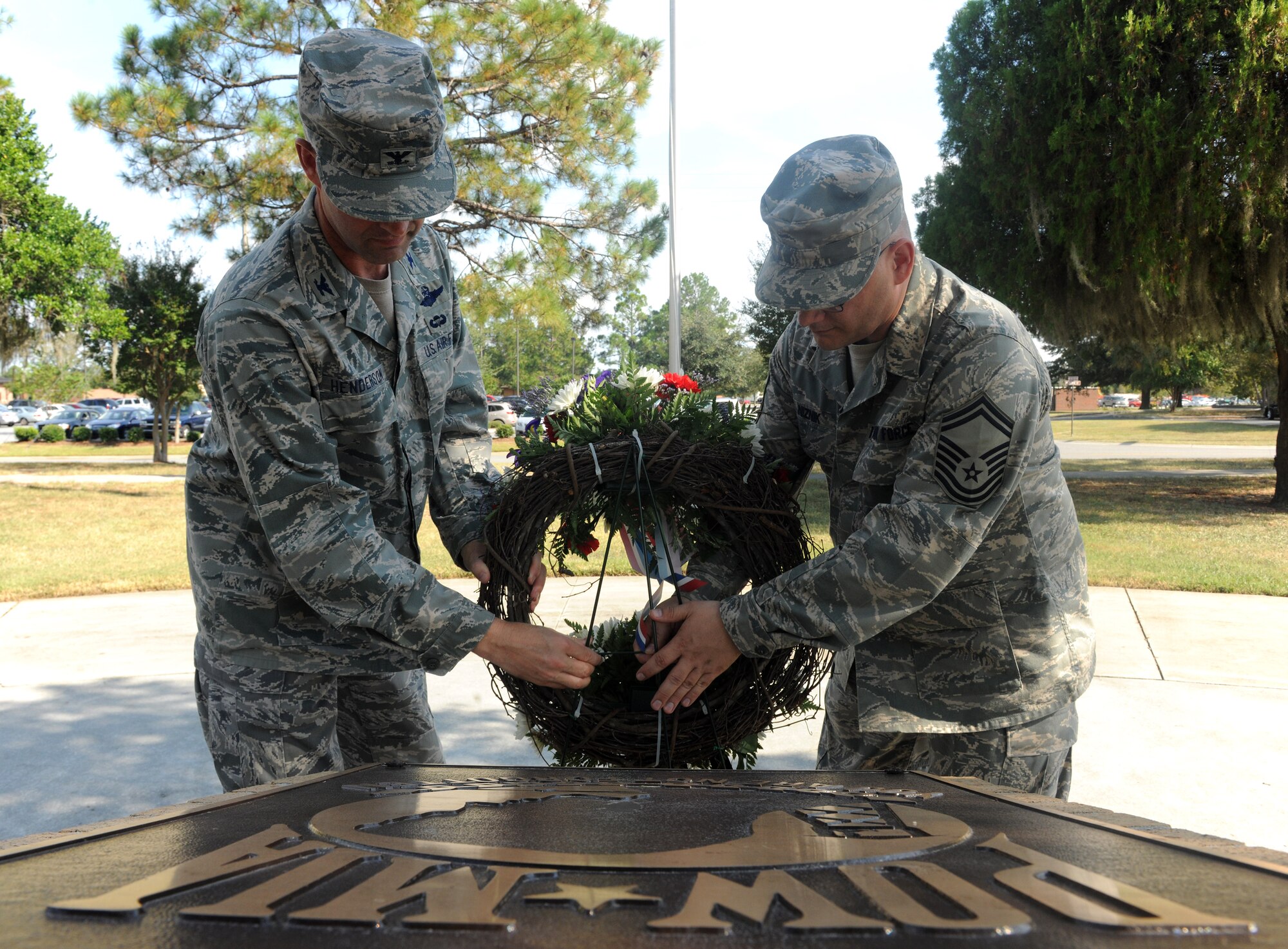 MOODY AIR FORCE BASE, Ga. -- Col. Gary Henderson, 23rd Wing commander, and Senior Master Sgt. T.J. Niznik, 23rd Maintenance Operations Squadron superintendant, hang a wreath in front of the Prisoner of War/Missing in Action Memorial during the POW/MIA Recognition Day Ceremony here Sept. 17. Taps was played as the wreath came to its final resting place during the ceremony. (U.S. Air Force photo/Airman 1st Class Benjamin Wiseman)
