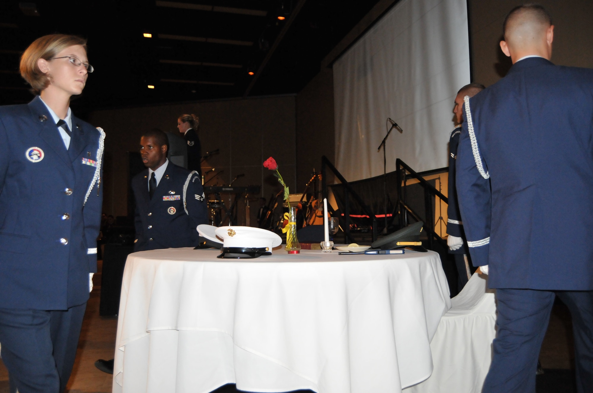 GOODFELLOW AIR FORCE BASE, Texas – Base Honor Guard members round the Table of Honor after setting the caps of the four branches of service, during the 63rd Annual Goodfellow Air Force Ball, Sept. 17. The table of honor ceremony acknowledges the inability of our missing to be with us in the celebrations, and to honor their sacrifice for this country. (U.S. Air Force photo/ Senior Airman Tong Duong)