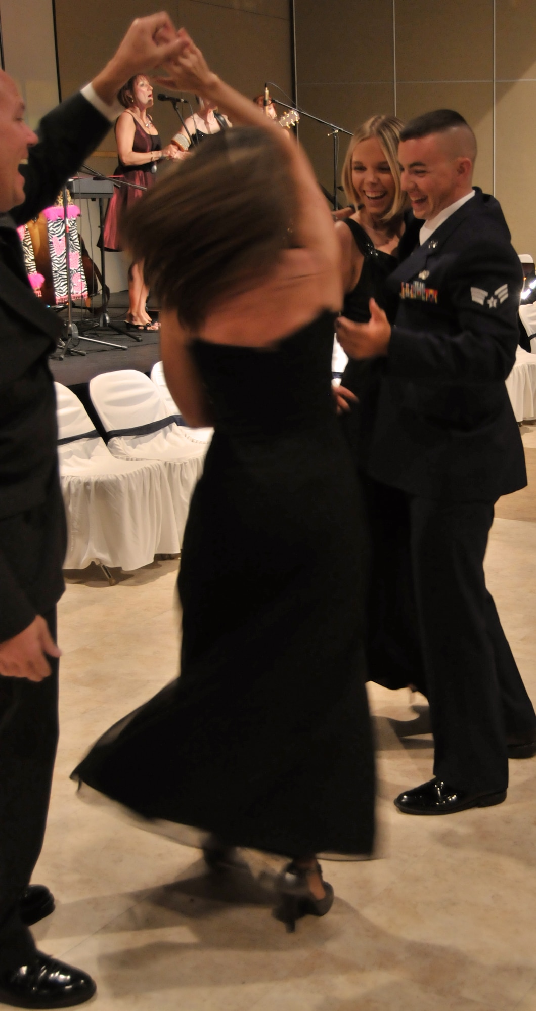 GOODFELLOW AIR FORCE BASE, Texas – FROM LEFT: Robert Mann gives Crystal Greer a spin as Senior Airman Jeffery Hart, 17th Training Group, and Heather Froehlich cheers on, during the 63rd Annual Goodfellow Air Force Ball, Sept. 17. The Divas, a local folk group entertained attendees. (U.S. Air Force photo/ Senior Airman Tong Duong)