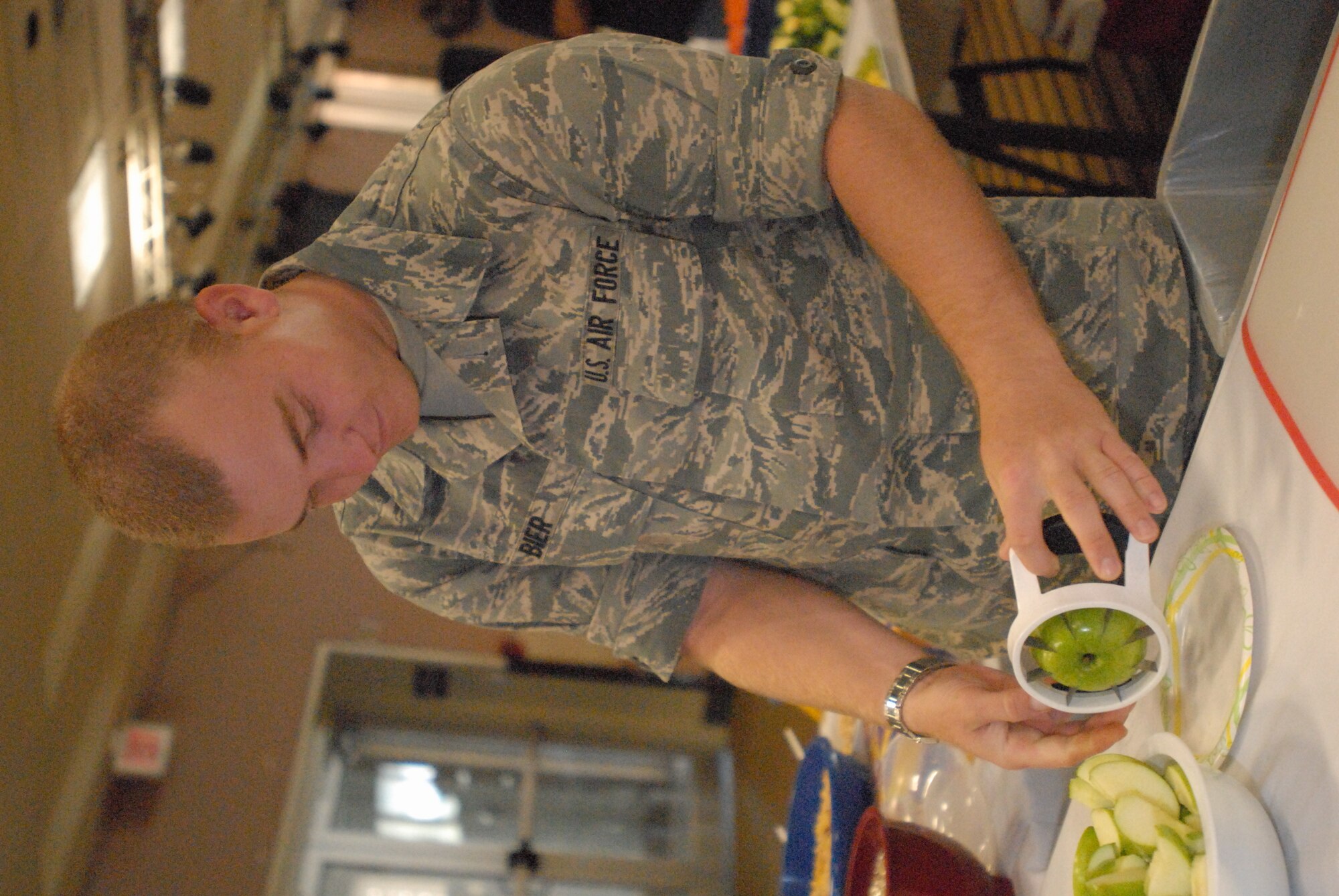 Airman Basic Joshua Bier, 315th Training Squadron, cuts apples during the first-ever family fun and information fair at the Event Center Sept. 18. The fair offered parents with special needs children information from various agencies throughout the base and San Angelo community, such as healthy diets, while crafts and activities were held for the children. (U.S. Air Force photo/Connie Hempel)
