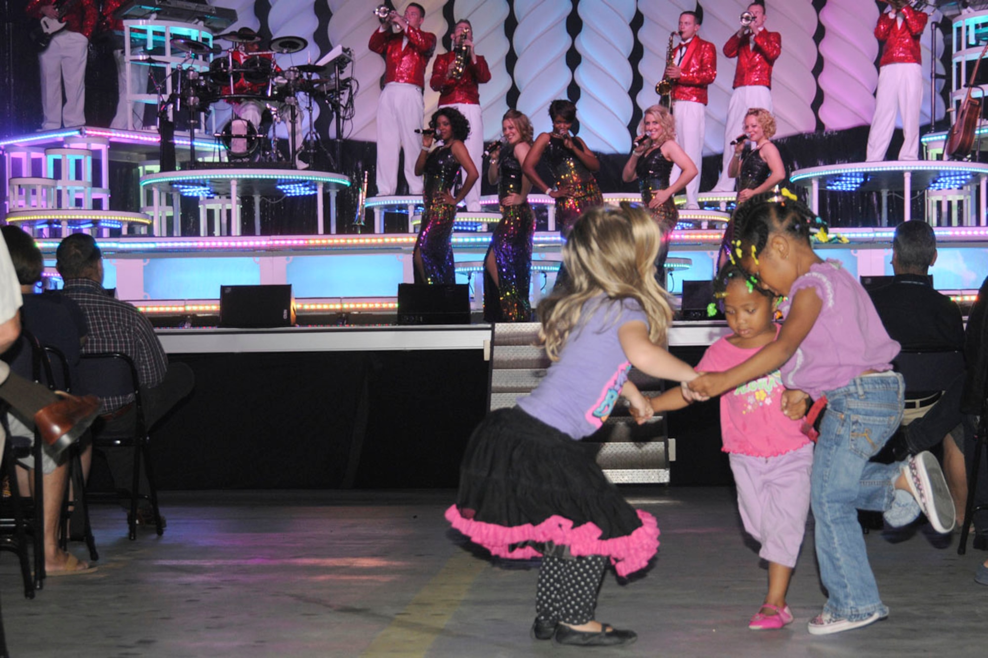 Children of Lajes Field dance to the music performed by Tops in Blue at the Portuguese Hangar during a visit to Lajes Sept. 14, 2010.   This year’s theme for the Tops in Blue performance is 'We Believe’ and their stop after Lajes Field will be Sept. 21, 2010 at Garmisch, Germany. (U. S. Air Force photo by Tech. Sgt. Chyrece Campbell)