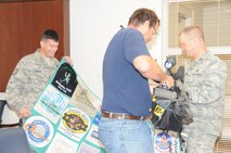 Capt. Christopher Woofter and TSgt. Stephen Woofter display one of the quilts their mother created out of the shirts they have worn to several marathons.(USAF photo by Staff Sgt. Terrica Y. Jones 916 ARW/PA)