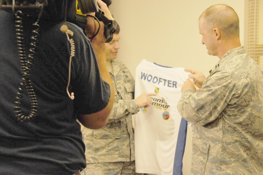 Capt. Christopher Woofter and TSgt. Stephen Woofter show their "Team Seymour" jersey for the Air Force Marathon to a camera crew from ABC-11 Raleigh. (USAF photo by Staff Sgt. Terrica Y. Jones 916 ARW/PA)