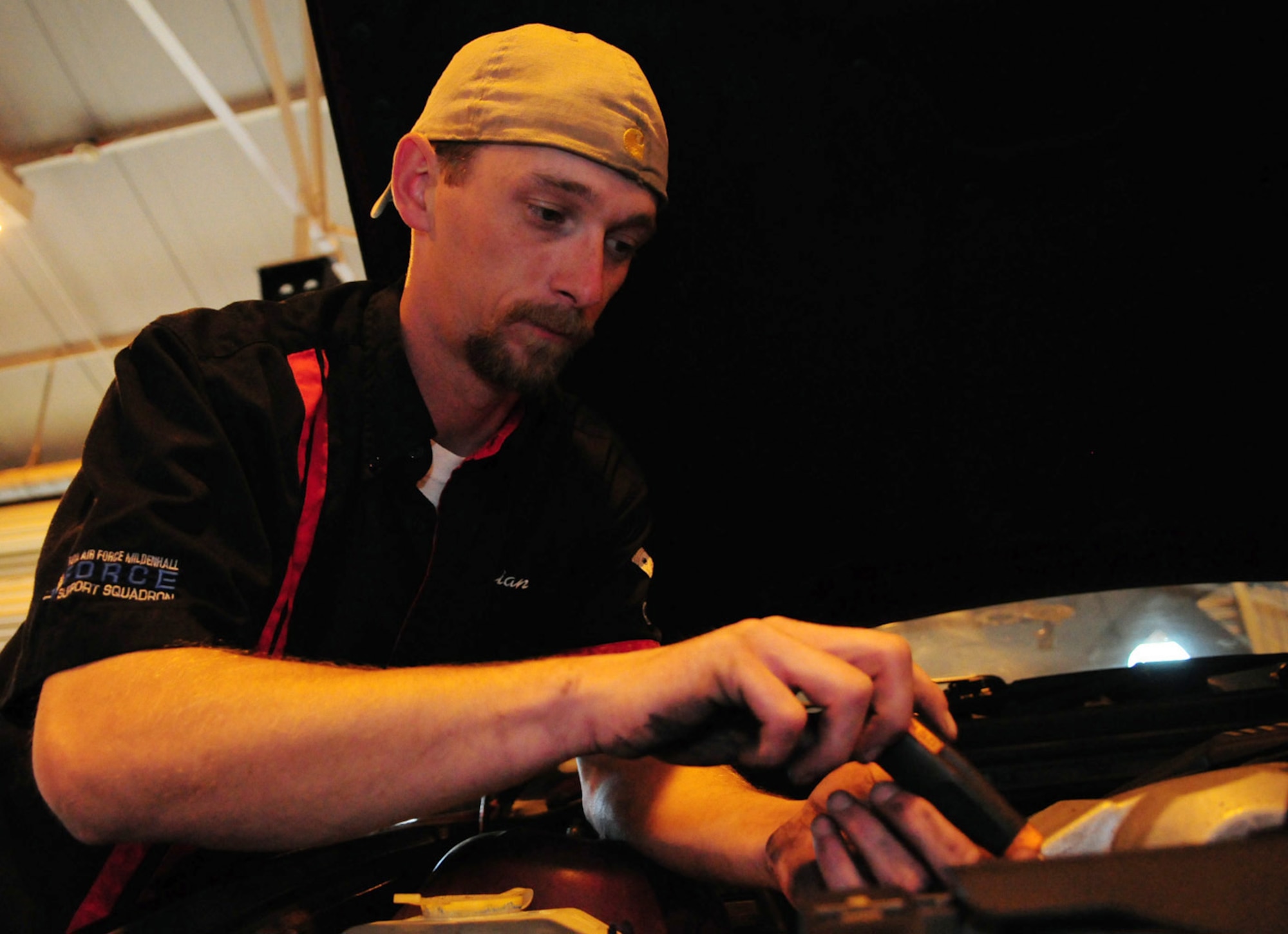 RAF MILDENHALL, England -- Brian Muse, 100th Force Support Squadron Auto Hobby Shop mechanic, removes an engine cover from a customer's here car so he can check the spark plugs. The auto hobby shop charges $60 per hour to have a mechanic work on a vehicle. Alternatively, for customers wanting to do their own repairs, bays may be rented for $5 per hour. (U.S. Air Force photo/Karen Abeyasekere)