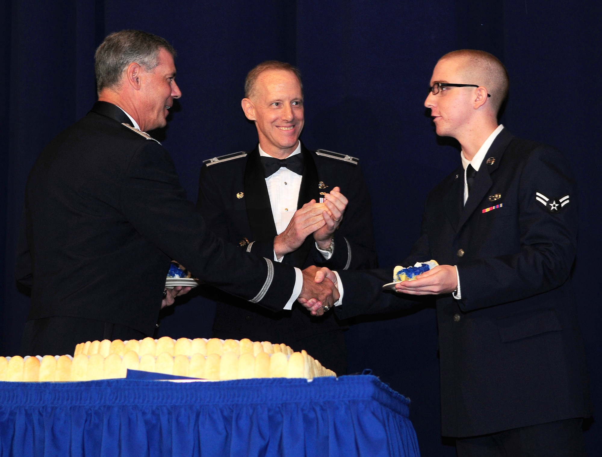 YOKOTA AIR BASE, Japan -- Fifth Air Force Vice Commander Maj. Gen. Sam Angelella, the most senior ranking Airman in attendance at Yokota's Air Force Ball, presents Airman 1st Class Tony Olson from the 730th Air Mobility Squadron and the most junior Airman present, a piece of cake symbolizing how our experienced Airmen nurtured and lead our young Airmen. (U.S. Air Force photo by Staff Sgt. Stacy Moless)