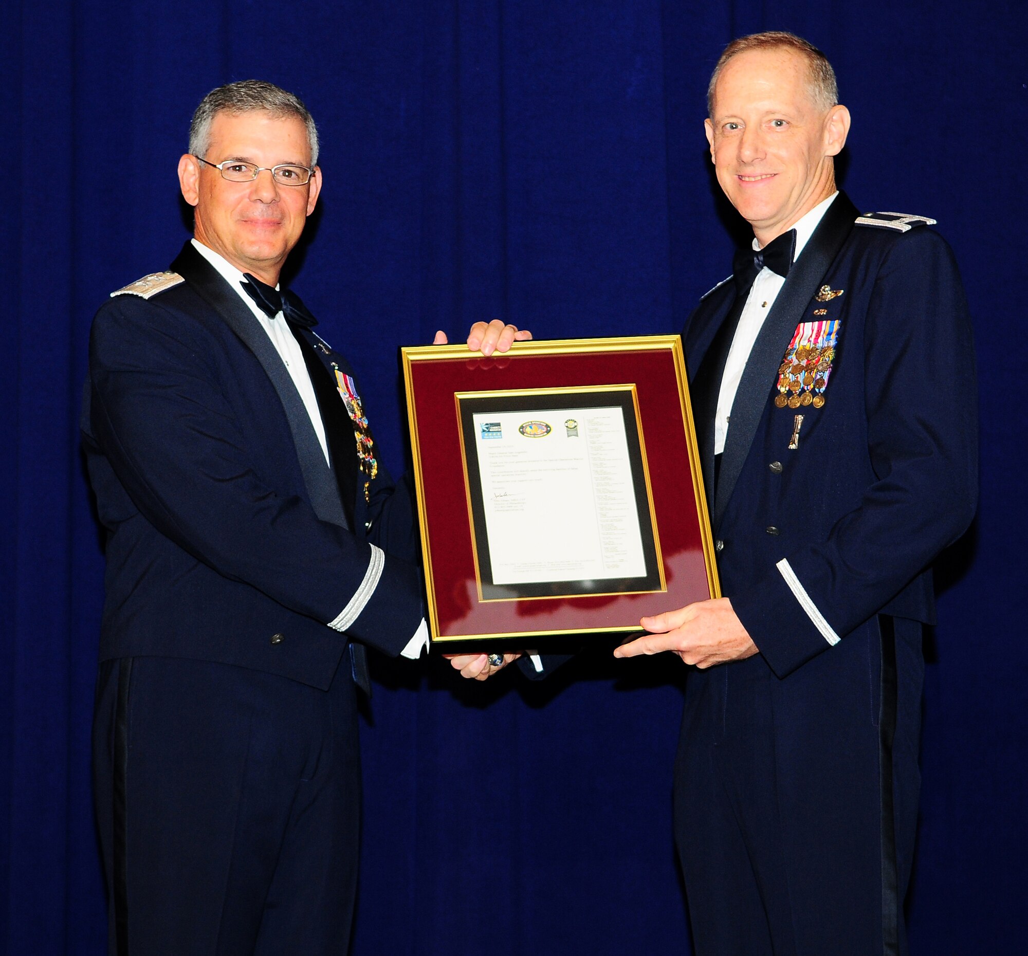 YOKOTA AIR BASE, Japan -- Colonel Otto Feather, 374th Airlift Wing commander, presents a plaque to Maj. Gen. Sam Angelella, Fifth Air Force vice commander, at Yokota,s Air Force Ball here, Sept. 18.  The gift was given to General Angelella on behalf of Team Yokota to thank him for his role as the guest speaker at the ball.  (U.S. Air Force photo by Staff Sgt. Stacy Moless)

