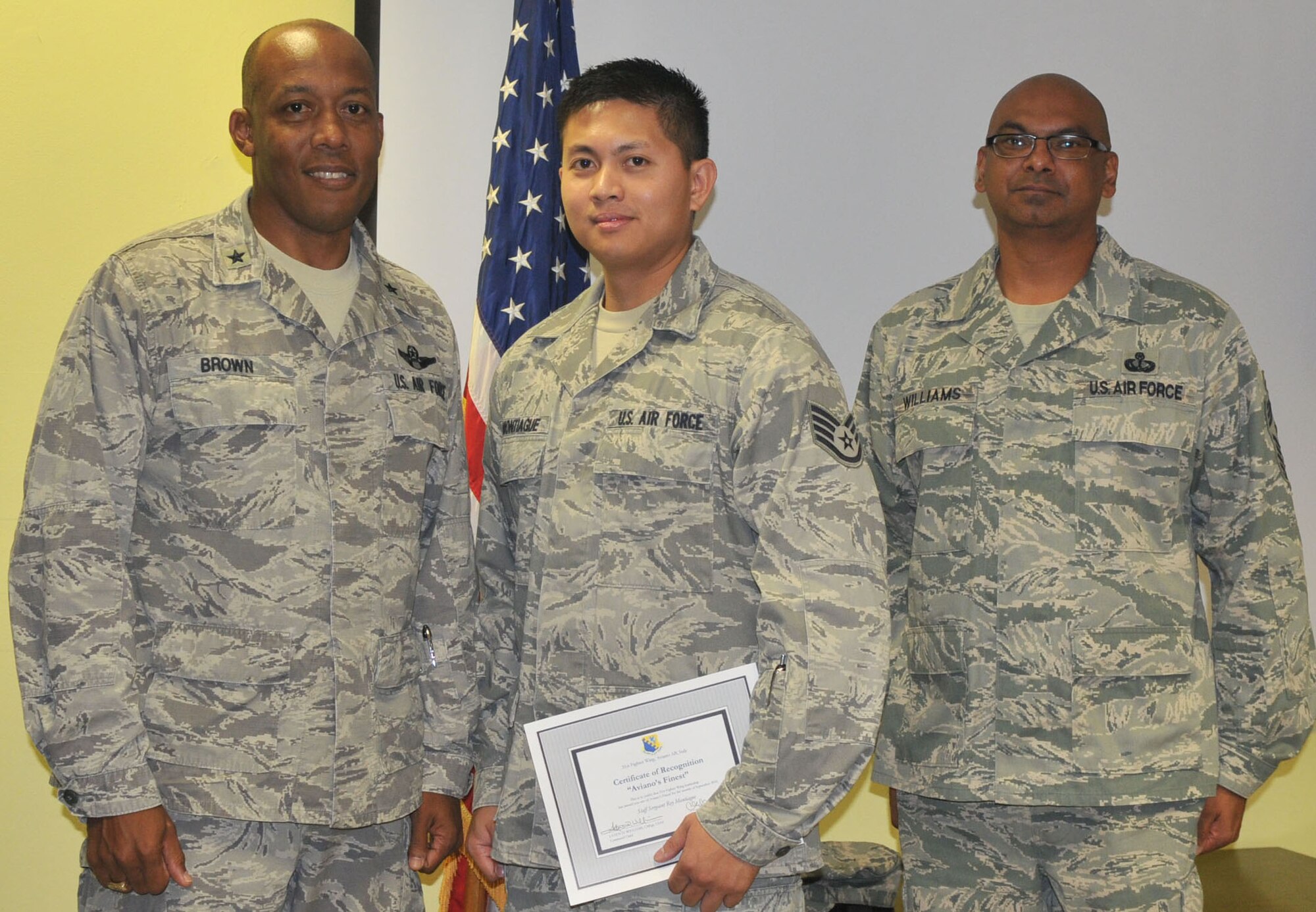 Brig. Gen. C.Q. Brown Jr., 31st Fighter Wing commander, congratulates Staff Sgt. Rey Montiague, 31st Logistics Readiness Squadron, on his selection as one of Aviano's Finest as Chief Master Sgt. Laten Williams, 31st FW command chief, looks on.(U.S. Air Force photo/Staff Sgt. MercedesKimble Crossland)