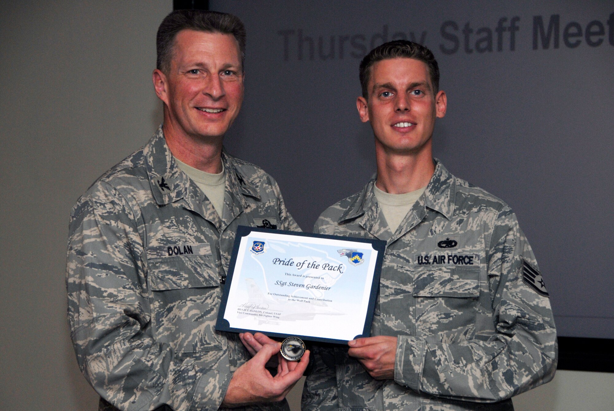 KUNSAN AIR BASE, Republic of Korea -- Col. John Dolan, 8th Fighter Wing commander, presents Staff Sgt. Steven Gardenier, 8th Aircraft Maintenance Squadron 35th Aircraft Maintenance Unit, with a Pride of the Pack award Sept. 16. (U.S. Air Force photo/Staff Sgt. Amanda Savannah)