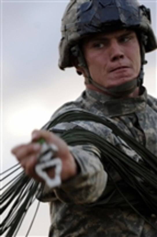 U.S. Army Spc. Douglas Mcneel, with 3rd Brigade Combat Team, 82nd Airborne Division, gathers his parachute after jumping from a U.S. Air Force C-130 Hercules aircraft over Fort Bragg, N.C., on Sept. 12, 2010.  