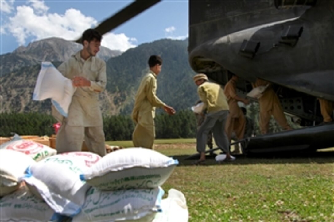 Pakistani men unload food transported by a U.S. Army CH-47 Chinook helicopter during humanitarian relief efforts in Rubicon, Pakistan, Sept. 15, 2010. U.S. forces have been helping Pakistan and its people to recover from disastrous floods.