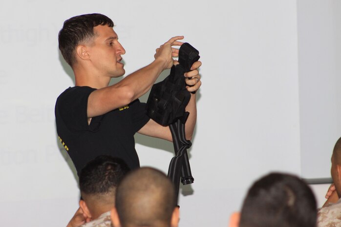 Sgt. Daniel M. DeCarvalho, Indoor Small Arms Range operations chief, shows training combat marksmanship coaches how to properly secure a pistol holster during the CMC course here Sept. 14 - 24. Marines were trained on how to coach for both the M-16 rifle and the 9mm pistol and were given the opportunity to take a pistol qualification before graduating from the course.