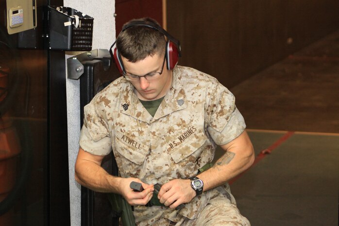 Sgt. Brad W. Atwell, Marine Aviation Logistics Squadron 12 aircraft electrician, instrument, flight control, system technician, loads a 9mm pistol magazine during pistol live fire for the Combat Marksmanship Coach course at the Indoor Small Arms Range here Sept. 14 - 24.