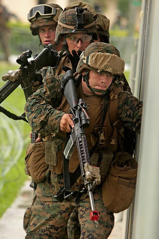 U.S. Marine Staff Sgt. Randy Whitmore, a platoon sergeant from Company A, 1st Battalion 7th Marines, leads soldiers from Company B, 1st Battalion Singapore Guards through a mock vehicle check point at the Murai Urban Training Facility here Sept. 22 in Singapore. The Marines and sailors from A Company trained alongside soldiers from Company B, 1st Battalion Singapore Guards as part of exercise Valiant Mark 11. Exercise Valiant Mark, in its 10th iteration, is an annual exercise conducted by U.S. Marines and the Singapore Armed Forces in order to maintain a high level of interoperability, enhanced military to military relations and to enrich mutual combat capabilities through combined training. Whitmore is from Reno, Nevada.