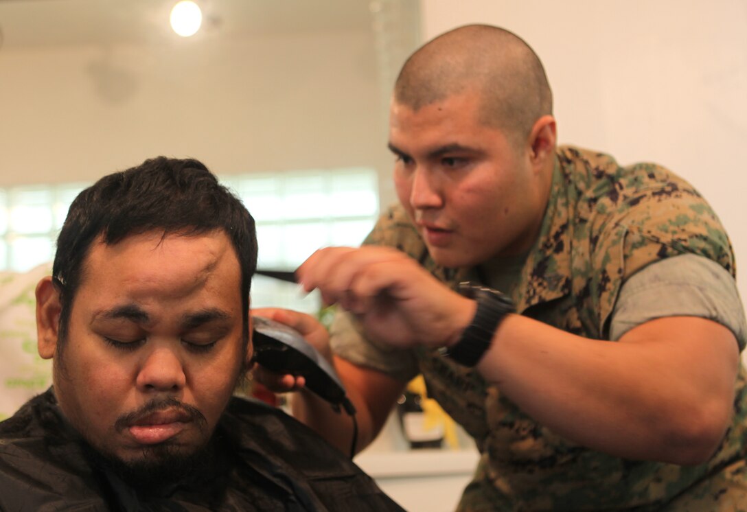 Cpl. Joe Sharp, Civil Affairs Team Leader, 31st Marine Expeditionary Unit, cuts the hair of Sean Hernandez, a patient at Guam Memorial Hospital Skilled Nursing Unit, Sept 21.  Marines and Sailors with the 31st MEU visited 30 patients at the GHM Skilled Nursing Unit to build relationships and to make a difference in the patients' lives for a day. The 31st MEU is operating on and around Guam, the westernmost territory of the U.S., conducting a Certification Exercise.