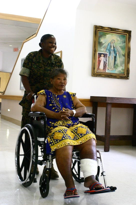 Lance Cpl. Courtney Rushin with Command Logistics Battalion 31, 31st Marine Expeditionary Unit, assists a patient of the Guam Memorial Hospital Skilled Nursing Unit during a community relations visit Sept. 21.  The 31st MEU is conducting a certification exercise in conjunction with exercise Valiant Shield.