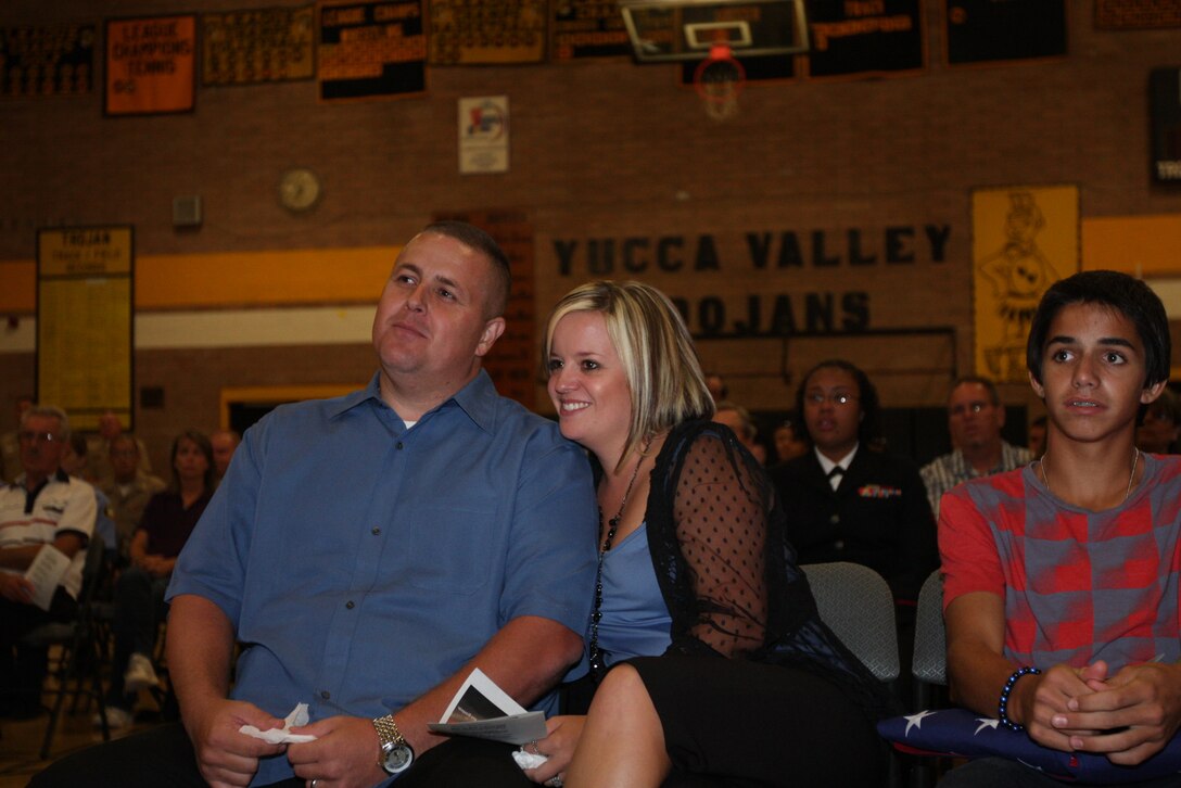 Brian Mullins and his wife, Brandi, embrace as a family friend shares an amusing story about Petty Officer 3rd Class James M. Swink, a native of Yucca valley Calif., who gave his life Aug. 27 while serving with 2nd Battalion, 9th Marine Regiment, in Helmand province, Afghanistan.