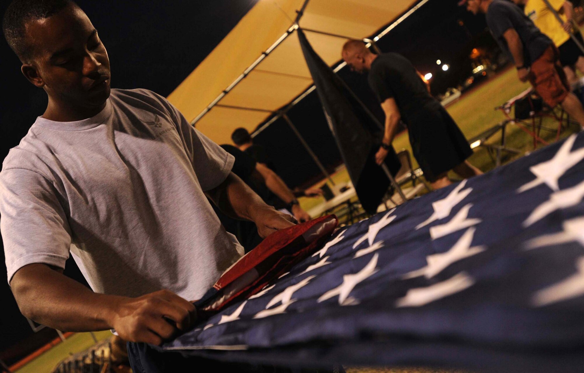 Staff Sgt. Darrell Walters, 25th Air Support Operations Squadron radio frequency operator, folds an American flag at 0500 hours Sept. 16 before a POW/MIA 24-hour relay at Joint Base Pearl Harbor-Hickam, Hawaii. In addition to the remembrance relay, the Air Force Sergeants Association organized a reveille and wreath-laying ceremony Sept. 17 to honor those 81,864 who are prisoners of war or missing in action. (U.S. Air Force photo/Staff Sgt. Carolyn Viss)