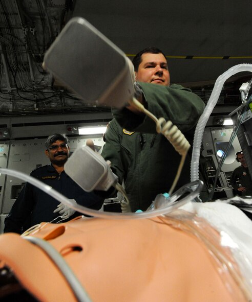 Major Matt Malan, a student in the Joint Medical Attendant Transport Team class, uses a defibrillator on a dummy during a JMATT C-17 training flight Sept. 16. The JMATT class provides aeromedical evacuation specialists didactic, hands-on, and experiential training on critical care air transport. (U.S. Air Force photo by Staff Sgt. Nathan Allen)