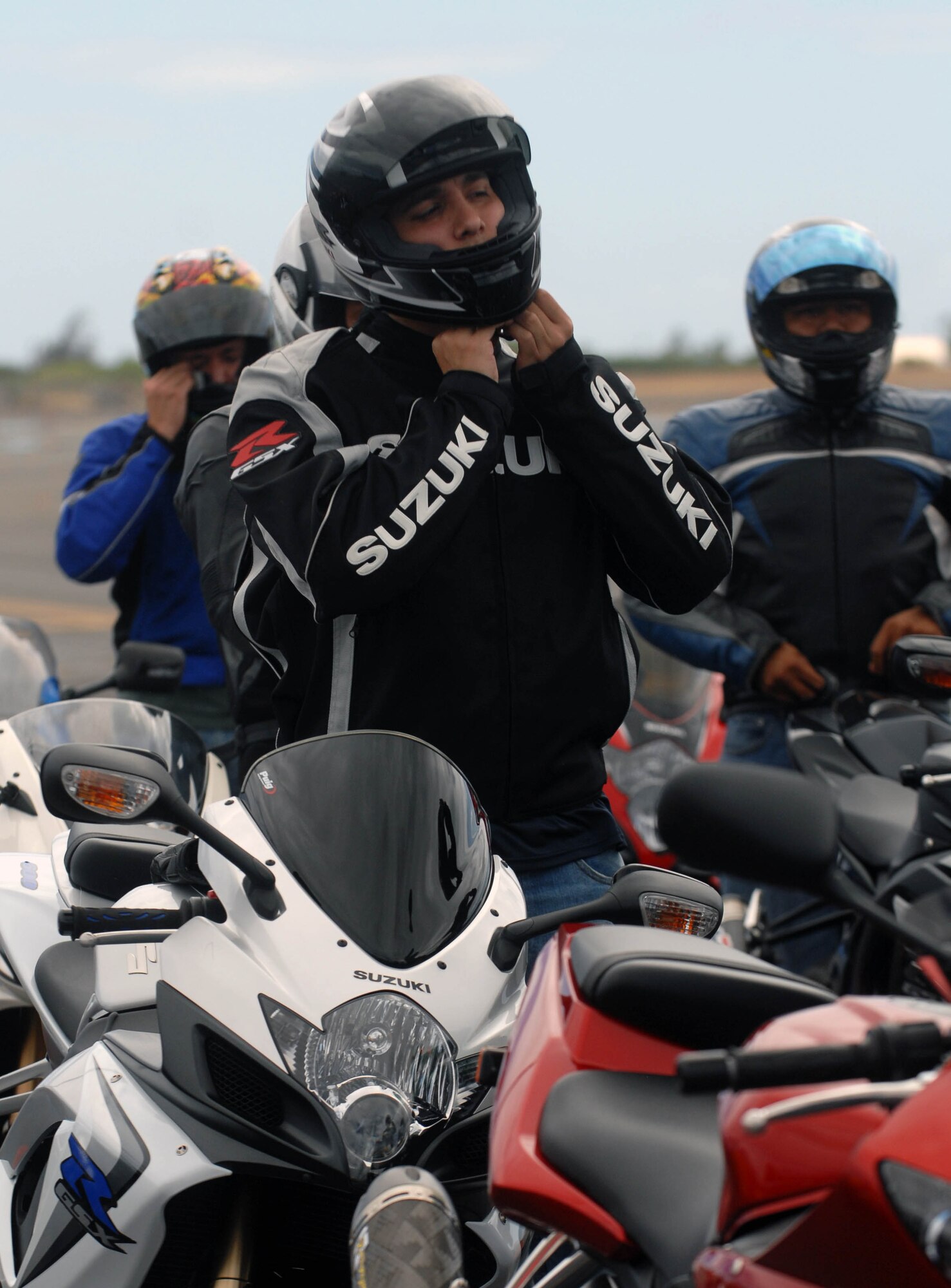 Riders don personal protective equipment during an Oahu-wide advanced motorcycle safety course on the flight line at Joint Base Pearl Harbor-Hickam, Hawaii, Sept. 15. The 15th Wing safety office hosted the Oahu-wide event for sister services Sept. 15 and 16. (U.S. Air Force photo/Staff Sgt. Carolyn Viss)