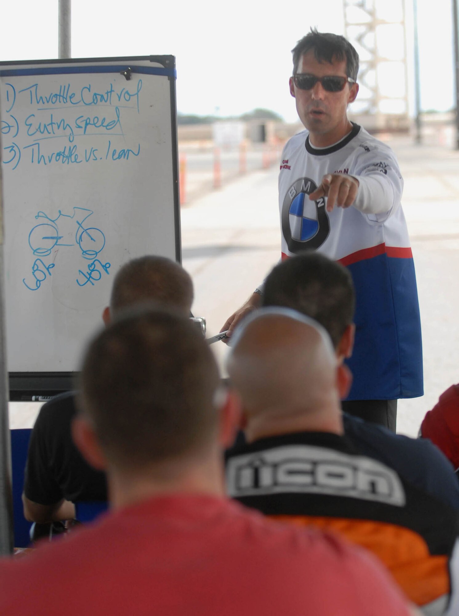 Dylan Code, an instructor from the California Superbike School, teaches a group of joint-service military members how to properly corner a turn on a motorcycle during training Sept. 15. The 15th Wing safety office hosted the Oahu-wide event at Joint Base Pearl Harbor-Hickam. (U.S. Air Force photo/Staff Sgt. Carolyn Viss)