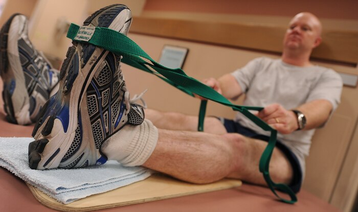 NELLIS AIR FORCE BASE, Nev.-- Master Sgt. Jeramie Brown, 99th Air Base Wing broadcast journalist, performs heels slides during a physical therapy session Sept 21.  Heel slides improve range of motion in and around the knee. (U.S Air Force Photo / Senior Airman Stephanie Rubi)