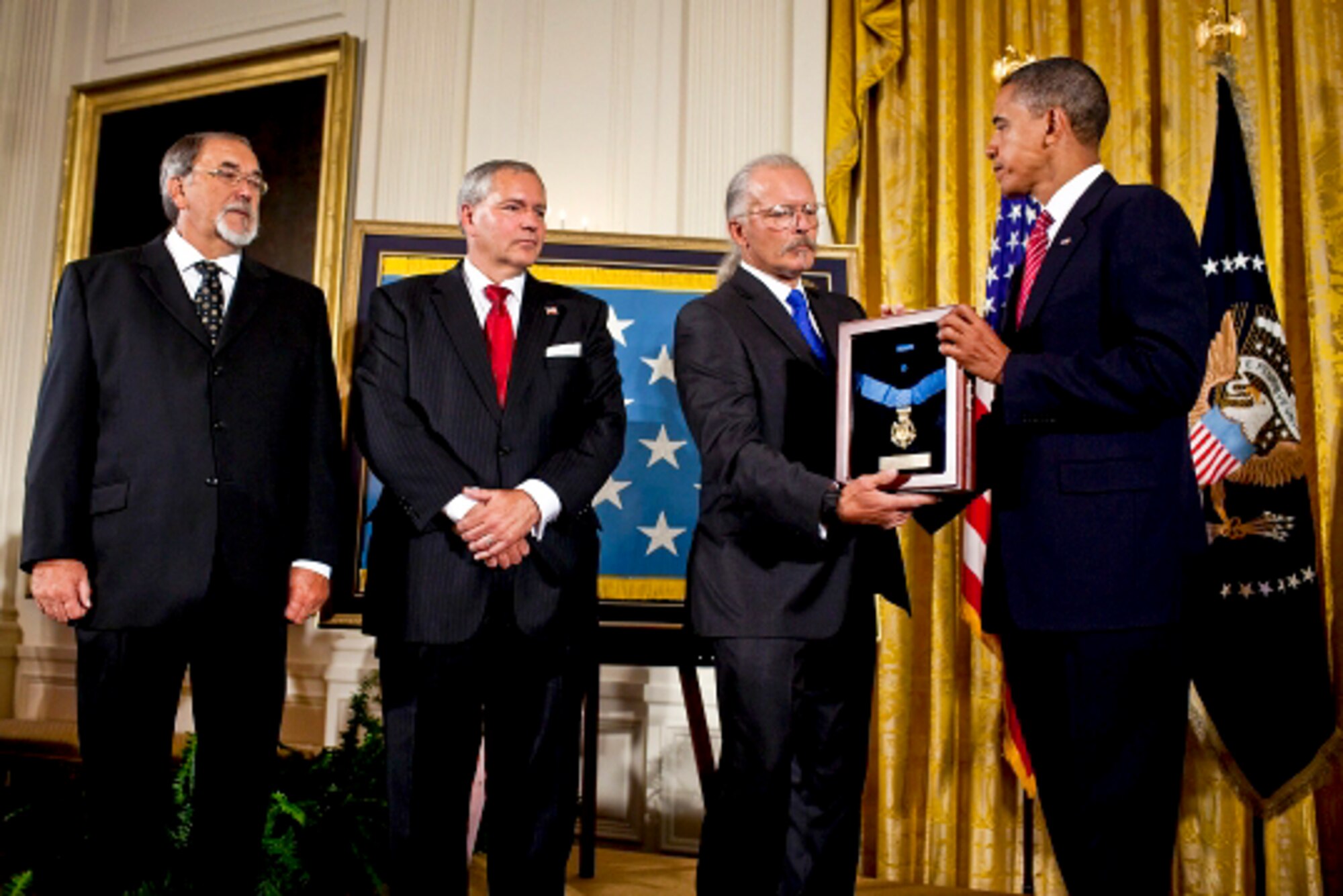 President Barack Obama presents the Medal of Honor posthumously to the sons of Air Force Chief Master Sgt. Richard L. Etchberger, honored for heroic actions in combat in Laos in 1968, during a ceremony in the East Room of the White House, Sept. 21, 2010. His sons are Steve Wilson (from left), Corey Etchberger and Richard Etchberger. (White House photo/Pete Souza)