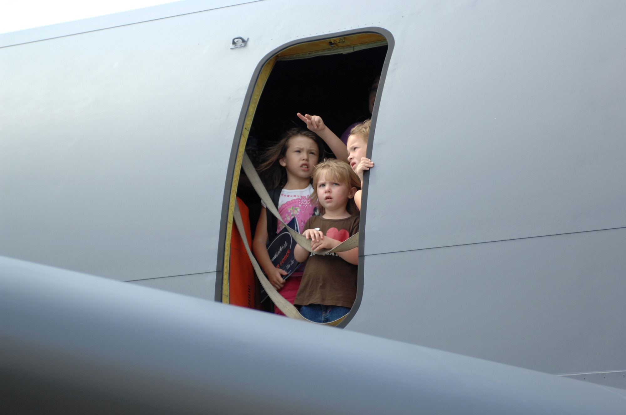 WHITEMAAN AIR FORCE BASE Mo. -- Young aviation enthusiasts look out the window of a C-17 Globemaster as the U.S. Army Golden Knights parachute demonstration team descends to the tarmac during the Wings Over Whiteman Air Show and Open House Sept. 19.  The two-day event was a celebration of military and civilian aviation.