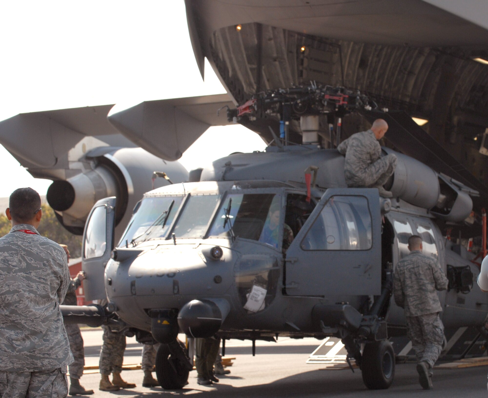 Members of the 106th Rescue Wing unload an HH-60 Pavehawk from a C-17 Globemaster III Sept. 18, 2010, at Air Force Base Ysterplaat, South Africa, for the Africa Aerospace and Defence 2010 exhibition. The New York National Guard sent an OH-58 Kiowa Scout and an HH-60 Pavehawk to participate in the exhibition. The event runs from Sept. 21 through 25. (U.S. Army photo/Staff Sgt. Inman Frank) 