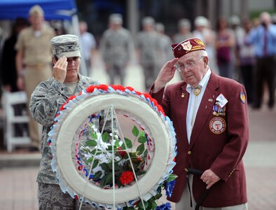 Col. Martha Meeker and Paul Hollen render salutes Sept. 17, 2010, on Joint Base Charleston, S.C., after laying a Prisoner of War/Missing in Action wreath to commemorate the sacrifices of POW/MIA heroes. The wreath was laid in memory of those who are still missing in action. Mr. Hollen served as a waist gunner on a B-17 when it was shot down over Germany in 1945. A rough parachute landing left Mr. Hollen face down in the German snow with a serious back injury. Nazi soldiers who found Mr. Hollen were brutal and unforgiving, he said. They took him prisoner, and he spent the next six months at a camp in Moosburg, Germany. Colonel Meeker is the 628th Air Base Wing Commander. (U.S. Air Force photo/Senior Airman Timothy Taylor)