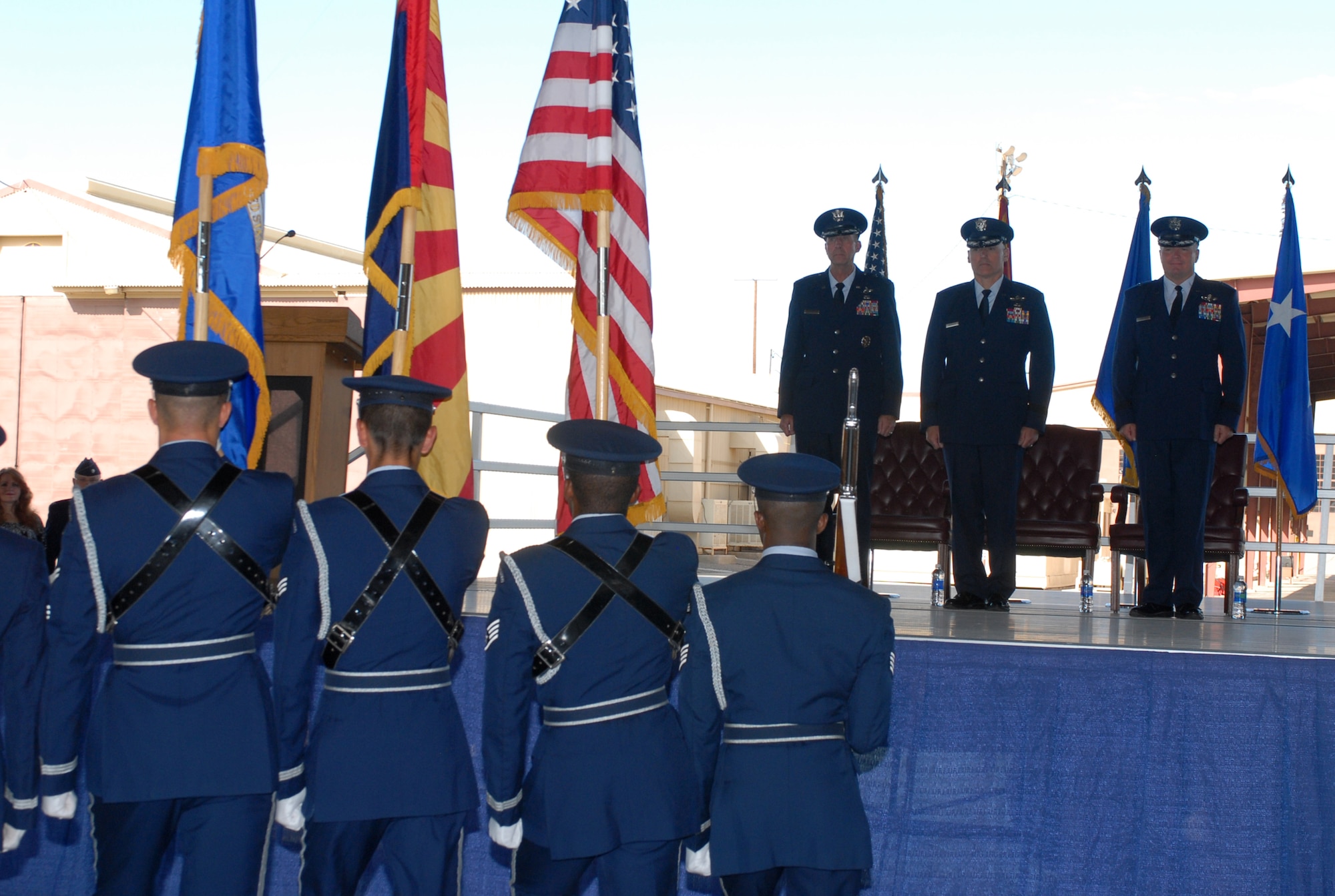 The Luke Air Force Base honor guard presents the colors during the 56th Fighter Wing change of command ceremony Sept. 20. On stage from left to right are: Maj. Gen. Mark Solo, 19th Air Force commander, Brig. Gen. Kurt Neubauer, outgoing 56th Fighter Wing commander and Brig. Gen. J.D. Harris, new 56th Fighter Wing commander. (U.S. Air Force photo/Airman 1st Class Sandra Welch)
