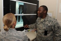 MINOT AIR FORCE BASE, N.D. -- Staff Sgts. Job Stringfellow and Carla Hisghman, both 5th Medical Support Squadron radiologists, look over X-rays from their training records to demonstrate how the light board works here Sept. 9. The 5th MDSS radiology shop supports the health of 5th Bomb Wing and 91st Missile Wing Airmen and family members who are all integral to the Air Force Global Strike Command mission. (U.S. photo by Airman 1st Class Aaron-Forrest Wainwright)