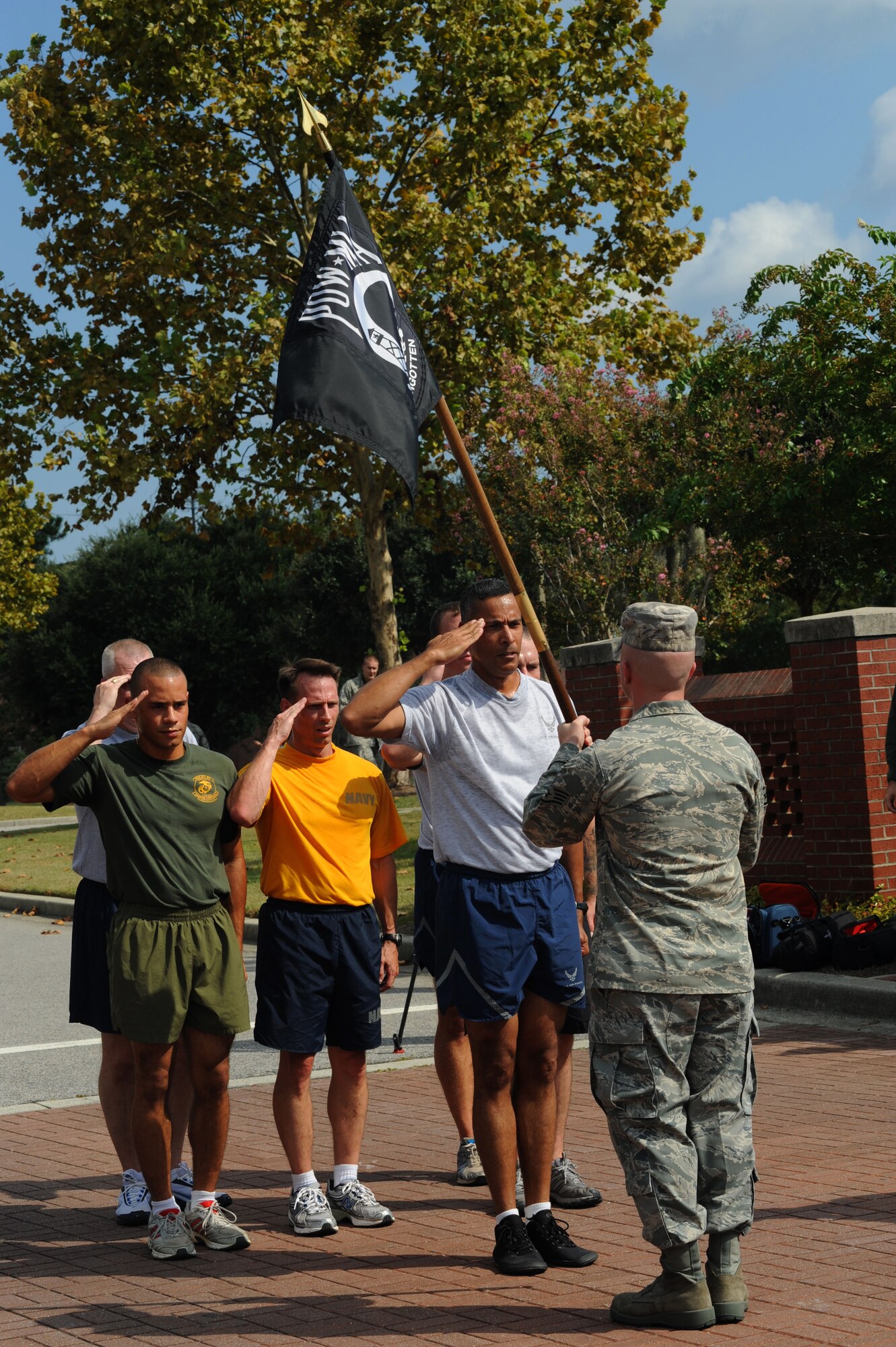 Service members from every branch render salutes to the Prisoner of War/Missing in Action flag following the end of a 24-hour run on Joint Base Charleston, S.C., Sept. 17, 2010. A series of teams held the running vigil at the base track, circling it until the last leg of the run. For the final portion of the run, a joint-service team was followed by a fire truck and two patrol cars as they ran down Hill Boulevard to the base parade grounds. (U.S. Air Force photo/Airman 1st Class Lauren Main)